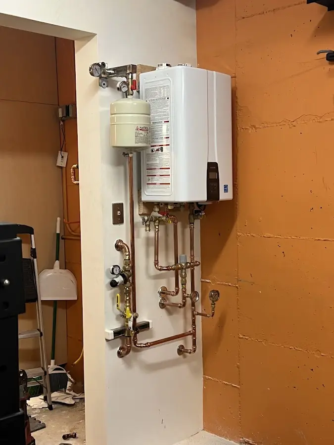 Plumbing technician inspecting water heater connections in Thousand Palms